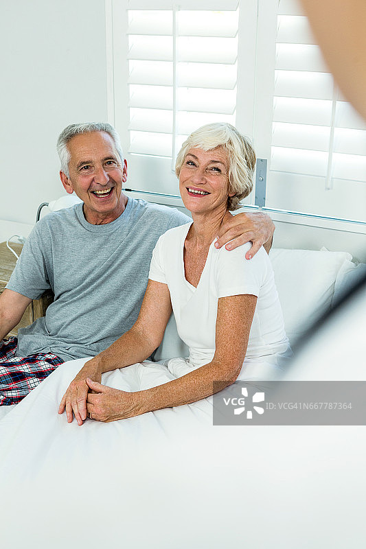 一对快乐的老年夫妇坐在床上图片素材