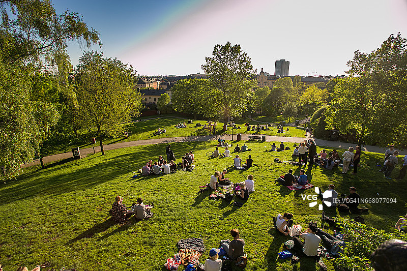 其余的人则在瑞典的斯德哥尔摩市中心、傍晚、草地公园、野餐图片素材