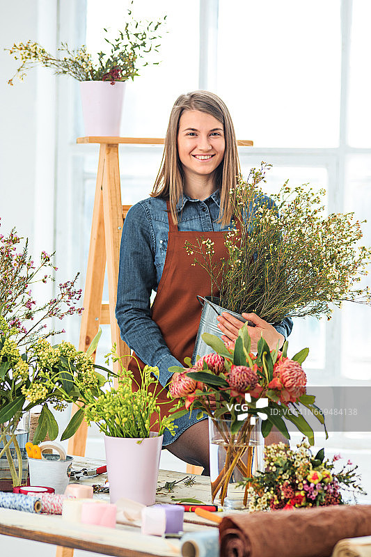 花商工作:年轻的女孩制作时尚的束不同的鲜花图片素材