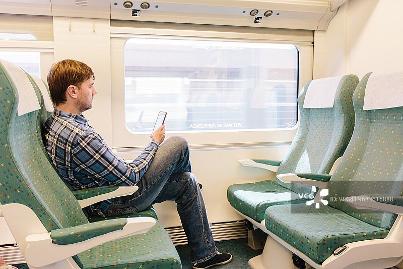 一名男子在高铁上使用智能手机图片素材