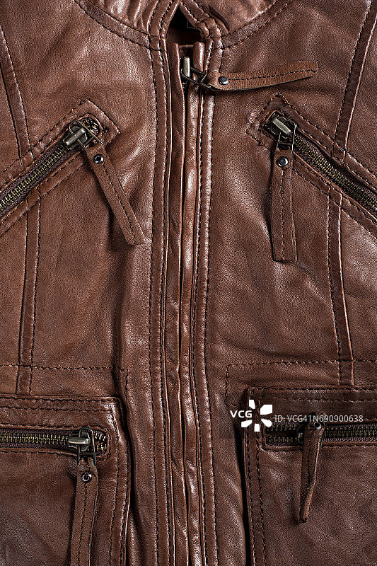 棕色有纹理的皮夹克。皮夹克宏观细节。夹克拉链和口袋图片素材
