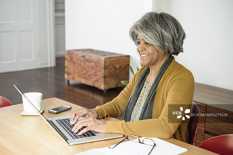 年长非洲裔美国人微笑着使用笔记本电脑图片素材