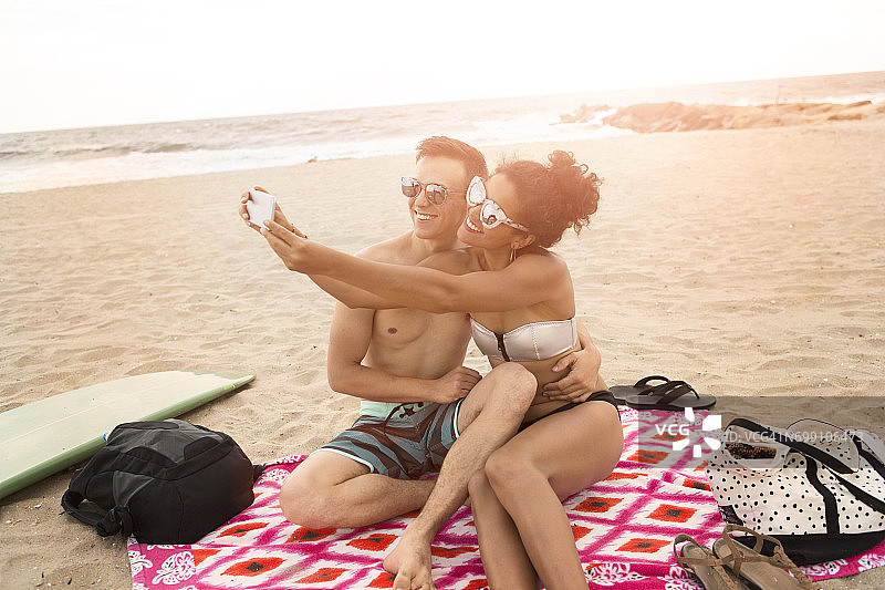 “年轻夫妇在美国纽约州洛克威海滩用智能手机自拍”图片素材