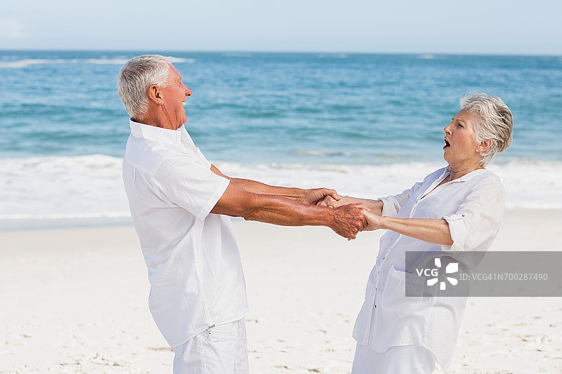 高年级情侣在海滩上跳舞图片素材