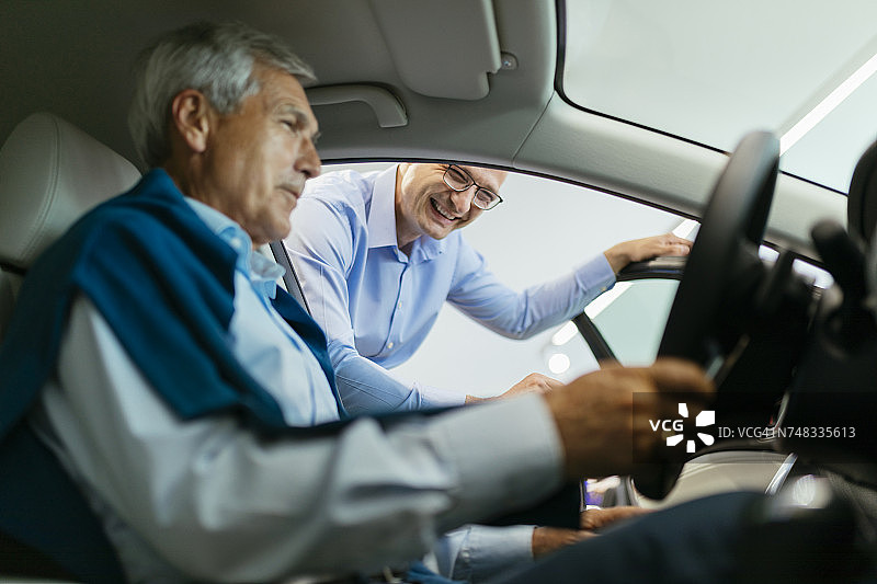 销售人员为汽车经销客户提供咨询图片素材