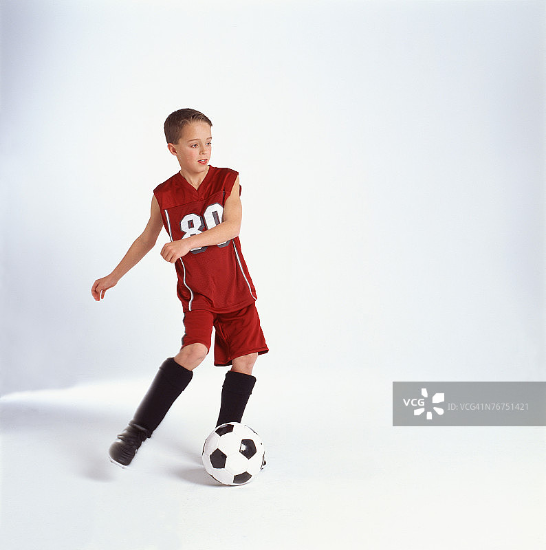 十来岁的男孩在踢足球图片素材