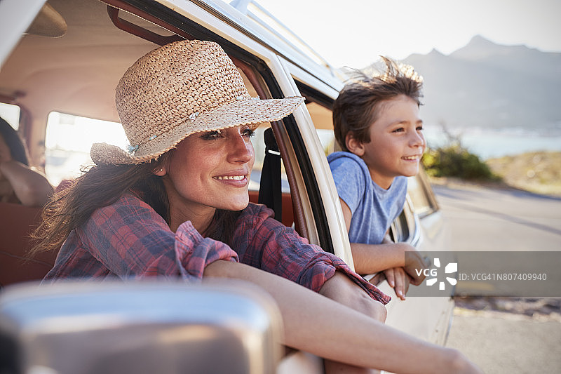 母亲和孩子放松在汽车在公路旅行图片素材