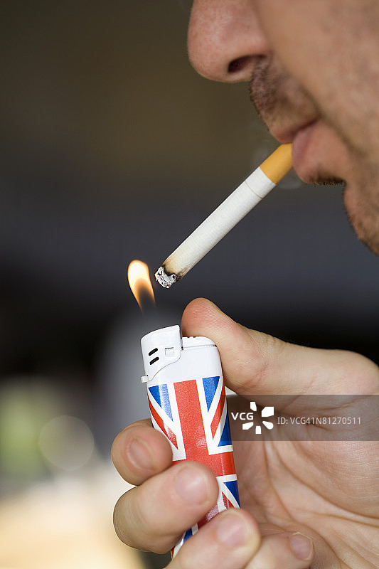 男子用英国国旗打火机点烟图片素材