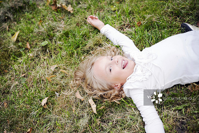 女孩躺在公园的草地上图片素材