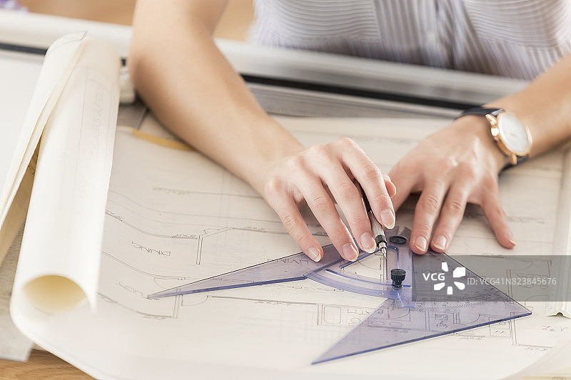 无法辨认的女建筑师用量角器绘制蓝图图片素材