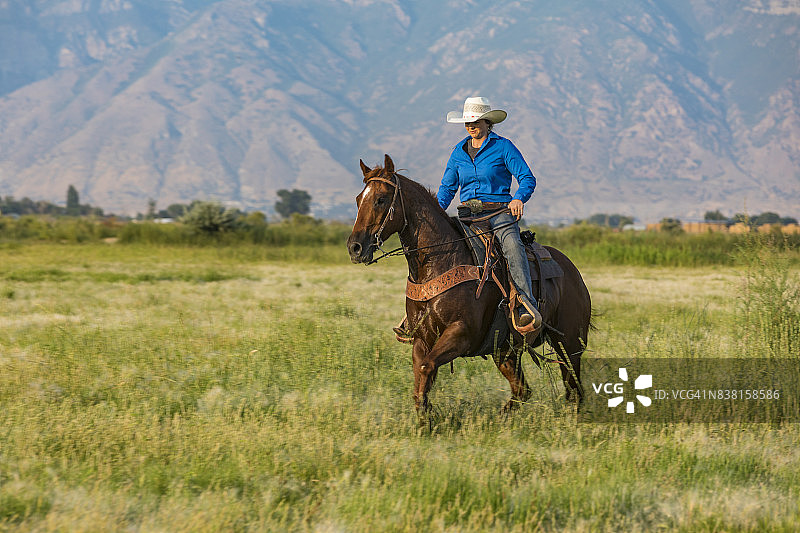 骑马穿越大草原的年轻女子图片素材