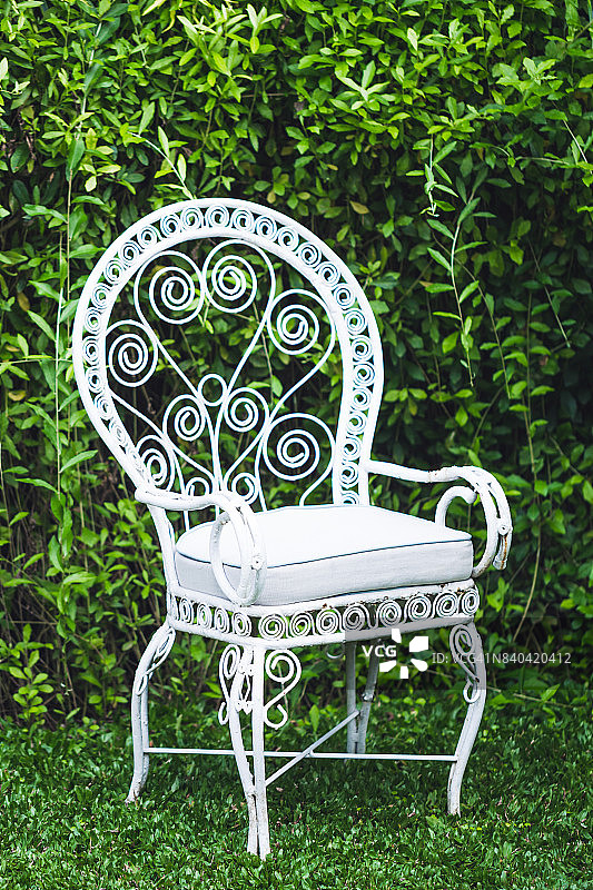 花园里的老式家具，以自然的绿色为背景。白色金属桌椅，老式欧式风格图片素材