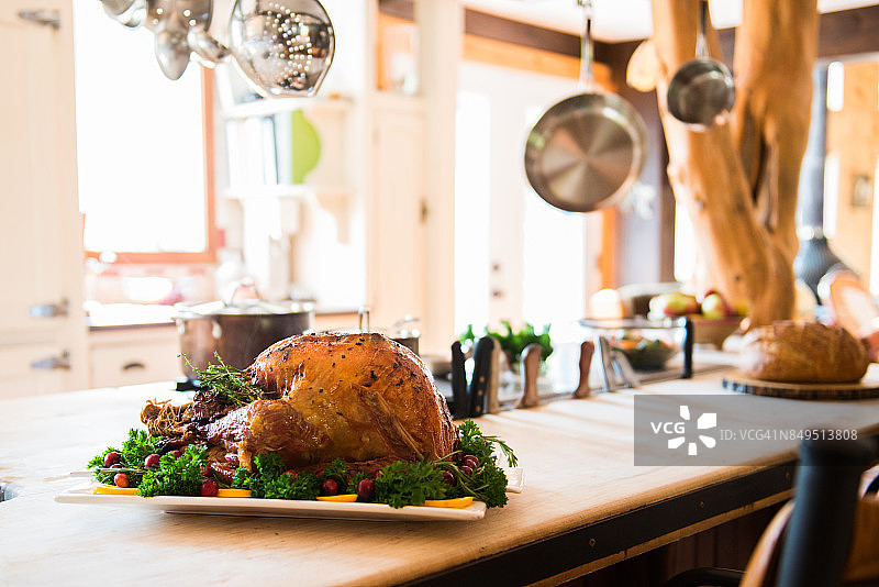 感恩节烤火鸡配菜和浅盘放在质朴的木桌上图片素材