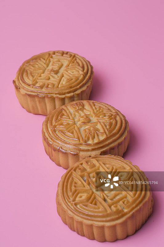 粉红色背景上的月饼。中国传统食物。图片素材