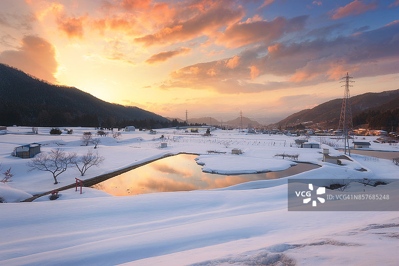 日本长野县山内镇的农村鸟瞰图，冬天稻田上覆盖着积雪。图片素材