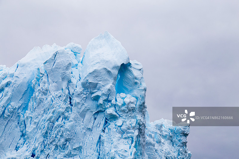 一座巨大的冰山从冰川崩解下来。展示了美丽的蓝色冰图片素材