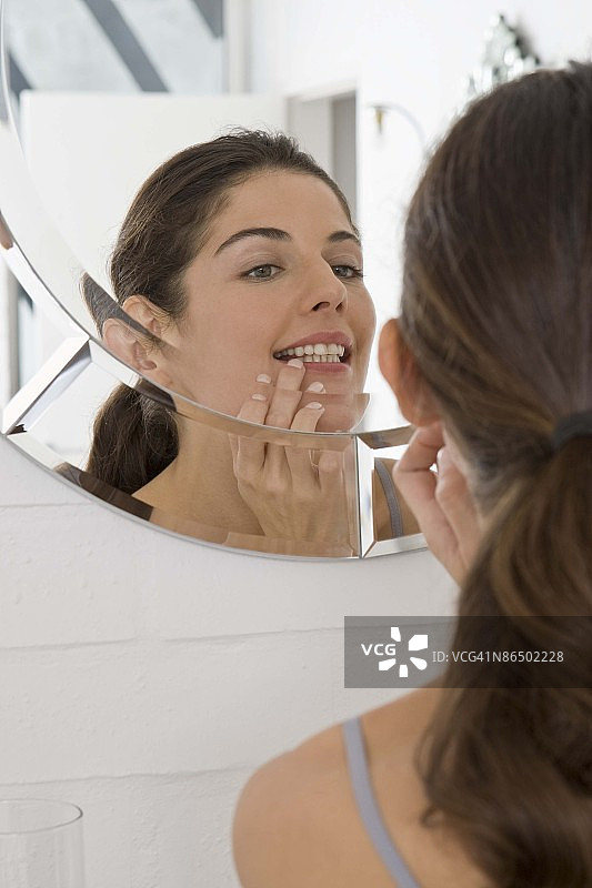 女人在浴室镜子前化妆图片素材