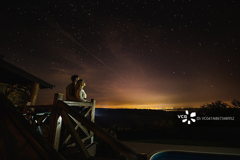 这对恋人在阳台上看壮丽的星座景观。图片素材