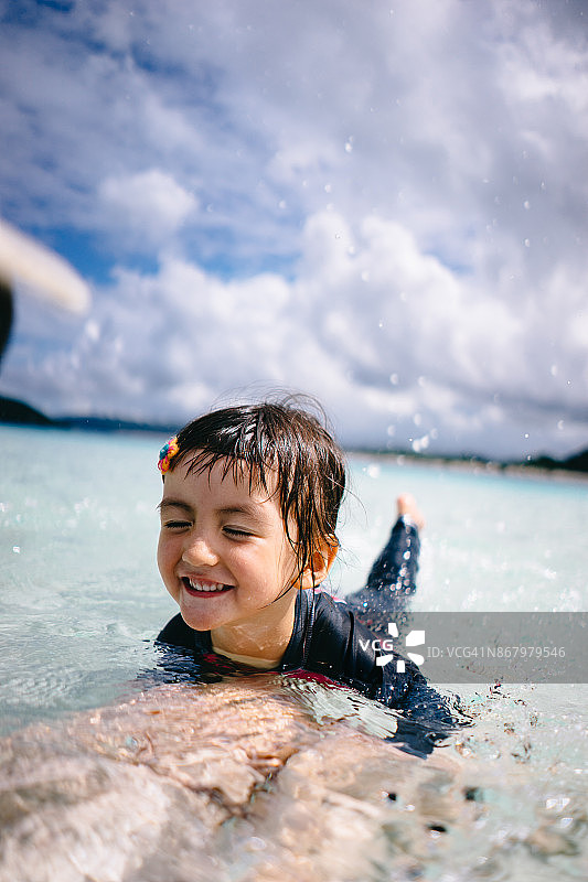 小女孩在日本冲绳的热带浅水里玩耍图片素材