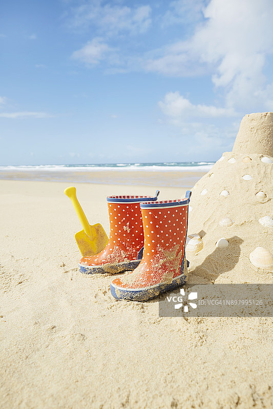 波尔卡圆点胶靴，沙堡和铲子在法国的海滩，欧洲图片素材