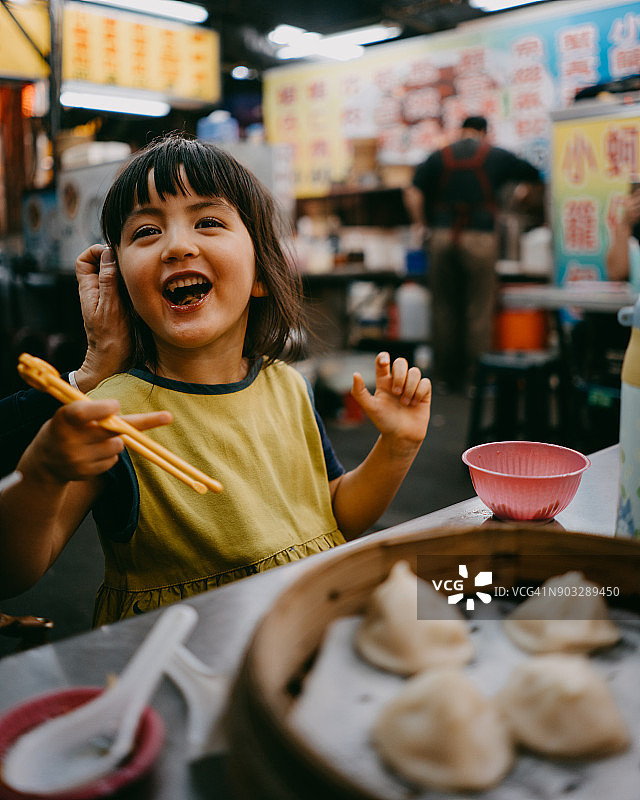 可爱的小女孩在台湾夜市享受晚餐时间图片素材