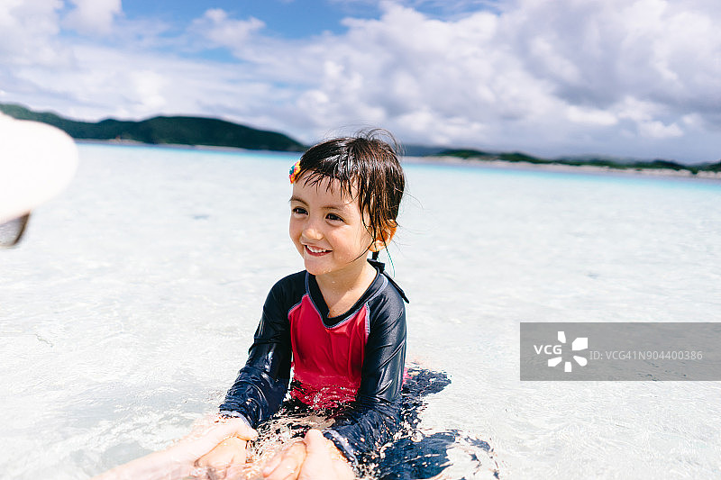 可爱的小女孩在热带浅水里玩耍，Zamami岛，日本图片素材