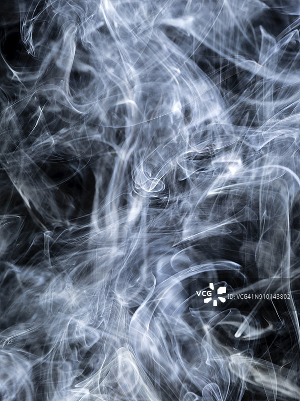 背景的形式和抽象的数字烟的颜色在一个黑色的背景。图片素材