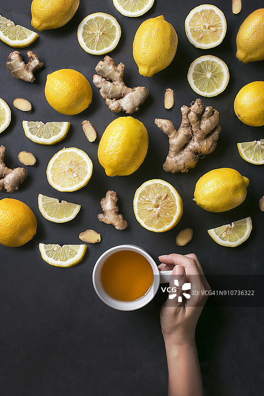 一杯柠檬姜茶在乡村的木制背景。图片素材