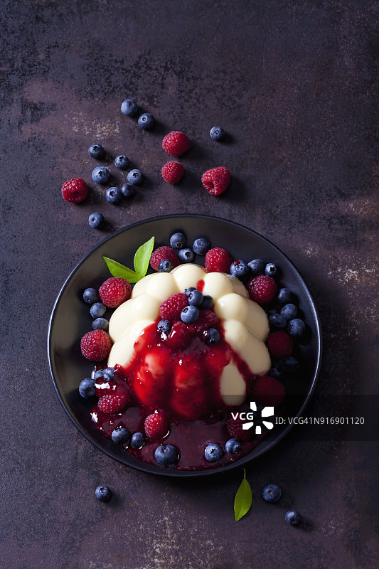 配上覆盆子、蓝莓和覆盆子酱的蛋奶冻图片素材