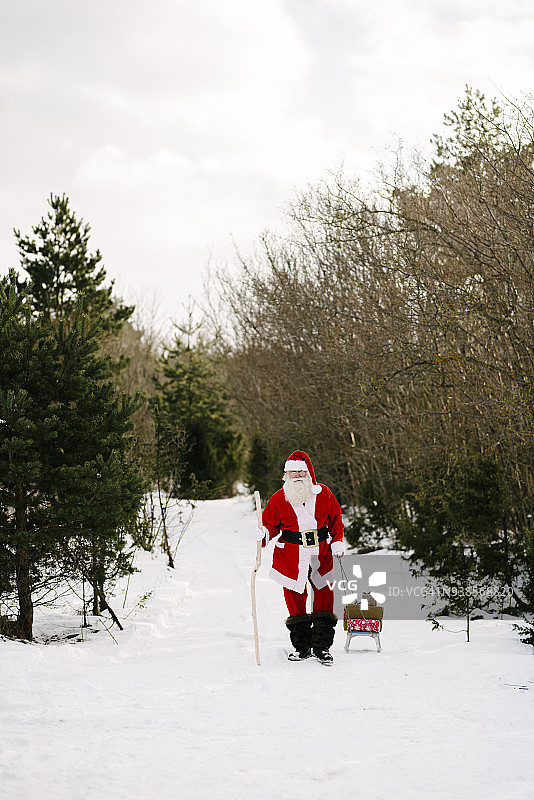 圣诞老人带着礼物坐在雪橇上图片素材