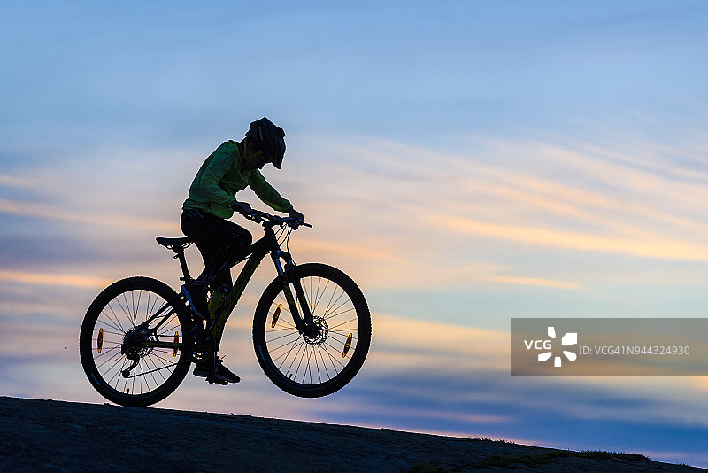 日落时分，男孩在海滩上骑自行车图片素材