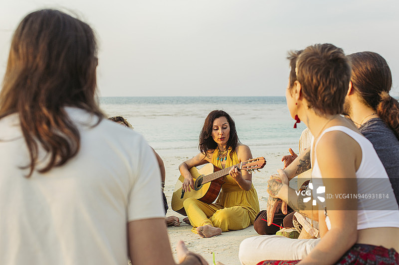 泰国，帕岸，一群人坐在海滩上，手里拿着吉他图片素材