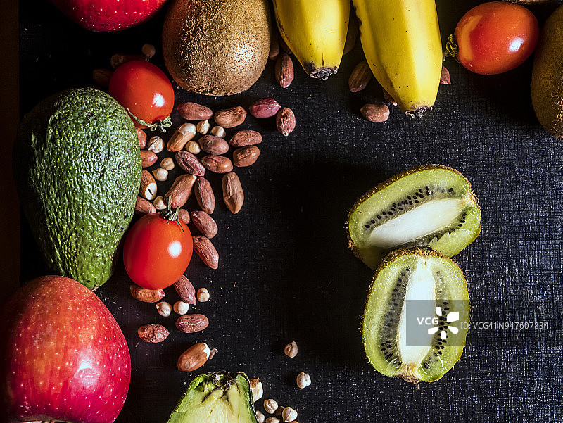 生的新鲜有机水果和种子与谷物在深色的表面图片素材