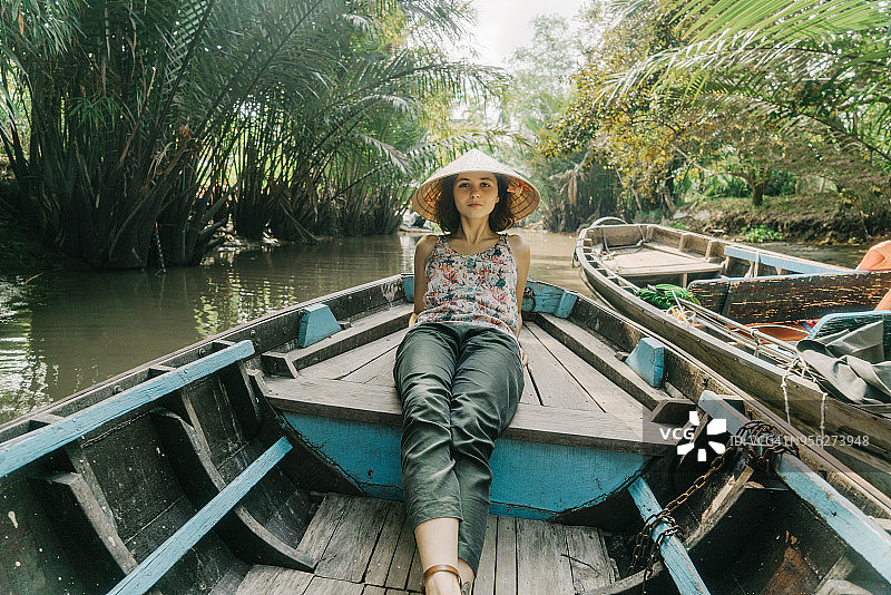 妇女乘船穿过湄公河三角洲和水上市场图片素材