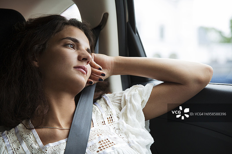 在车里旅行时，体贴的女人看向别处图片素材