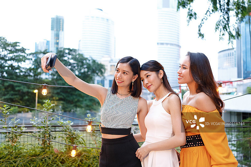 亚洲女性朋友在户外屋顶派对上自拍图片素材