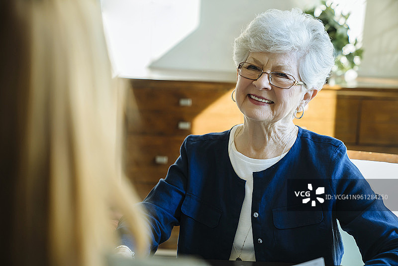 微笑的年长妇女讨论与财务顾问在办公室图片素材
