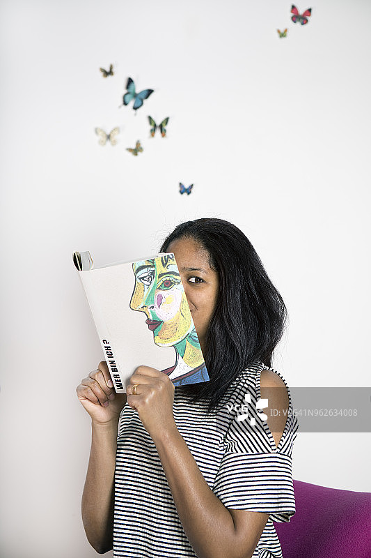 女人用书遮脸，用蝴蝶读诗图片素材