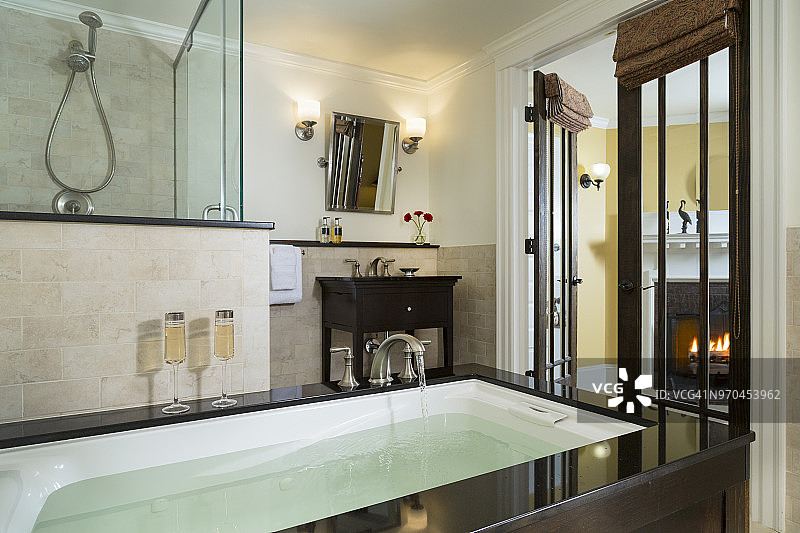豪华浴室，浴缸，香槟，壁炉和淋浴图片素材