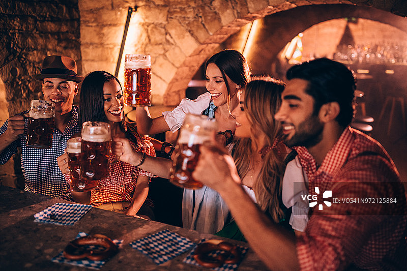 快乐的多民族朋友和情侣在酒吧庆祝啤酒节图片素材