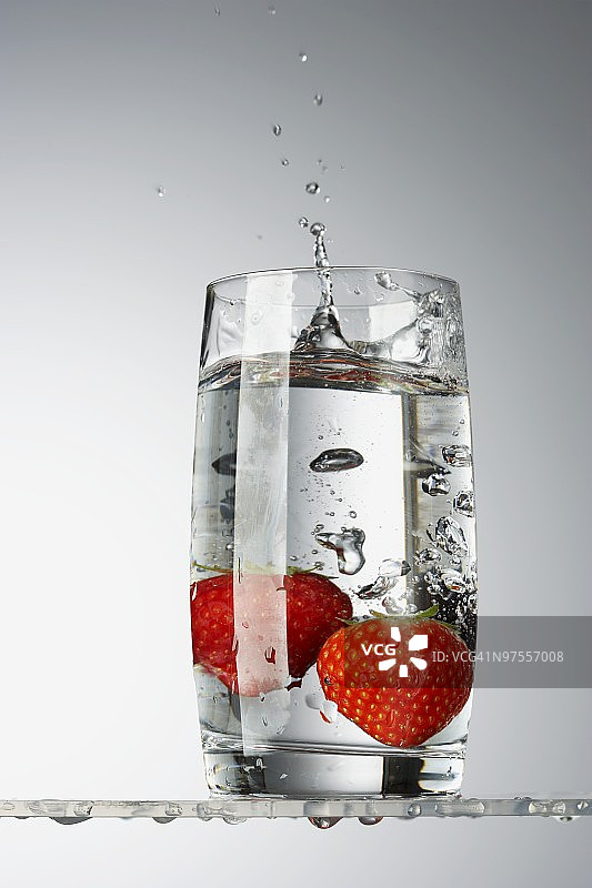 两颗草莓放在一杯水里图片素材