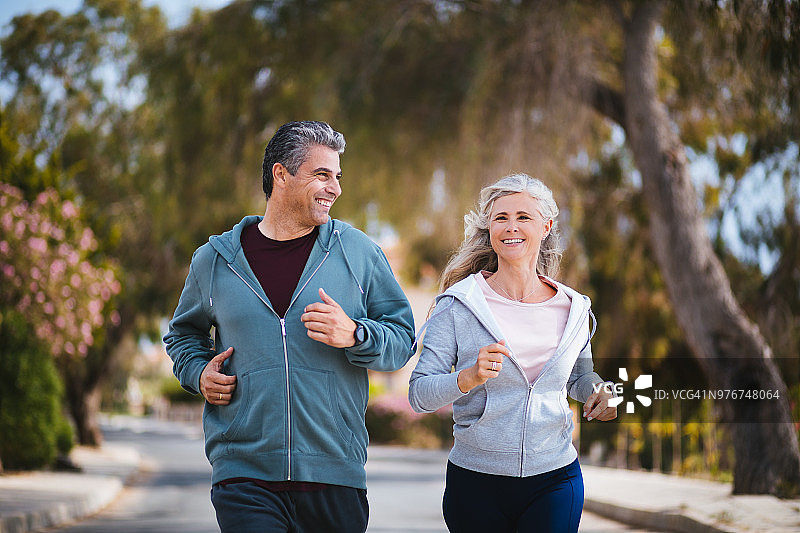 快乐的多民族退休成熟夫妇在春天一起慢跑图片素材