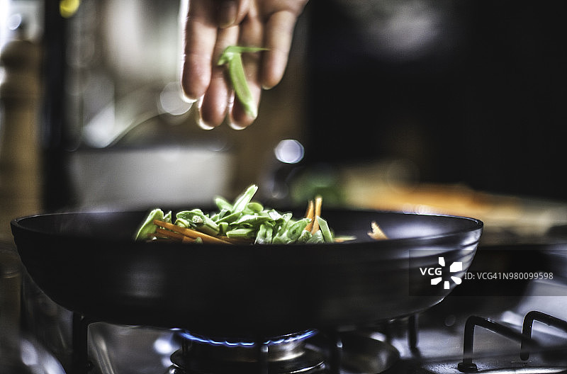 把蔬菜丝撒在平底锅里做韩国煎饼。图片素材