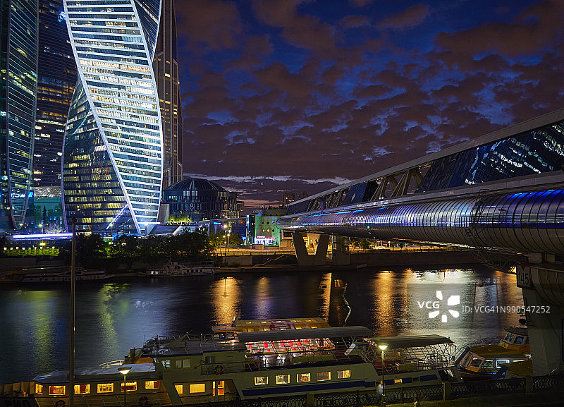 黄昏时分，靠近办公大楼和人行天桥的河边码头图片素材