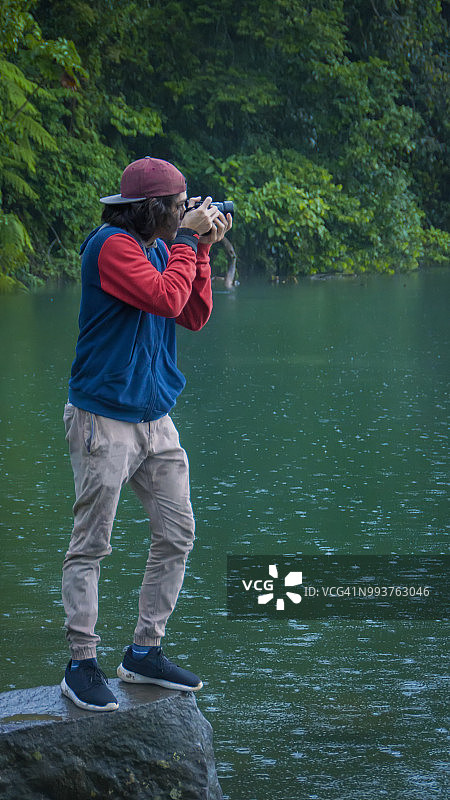 一名年轻人在热带雨林拍照图片素材