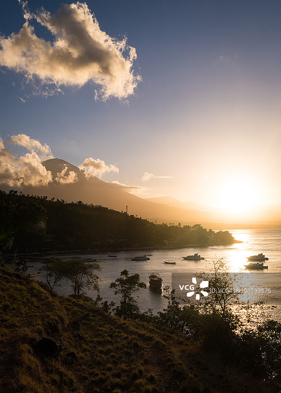 令人惊叹的日落在阿米德海滩和海湾与阿贡火山的背景在印度尼西亚巴厘岛图片素材