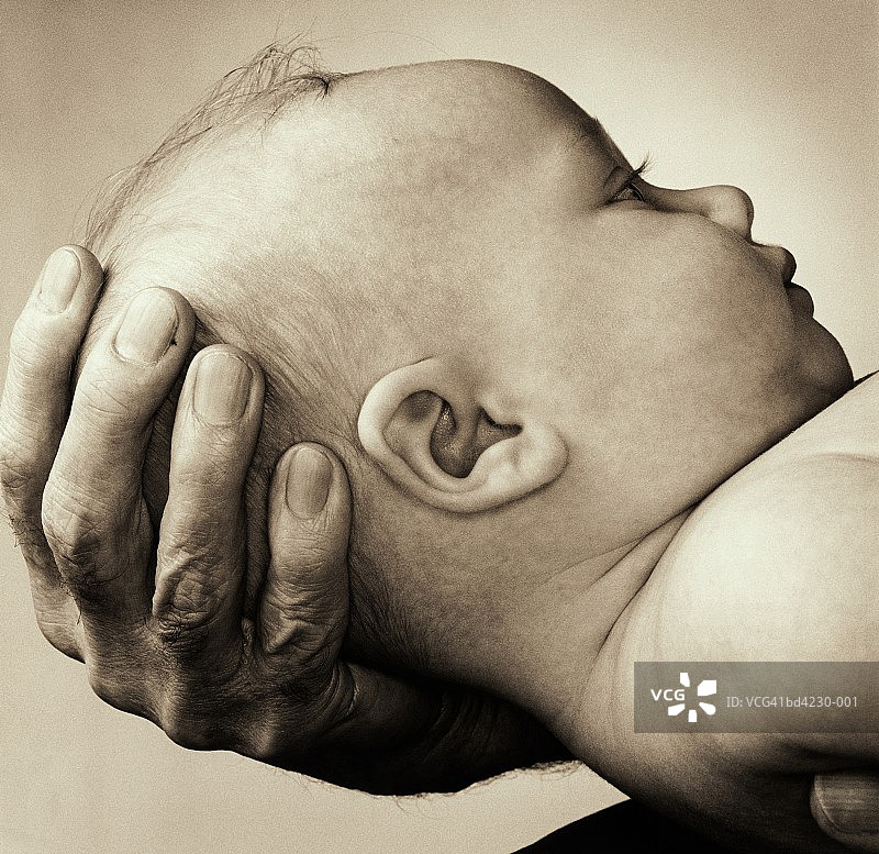 婴儿(3-6个月)在男人的手中，特写(色调B&W)图片素材