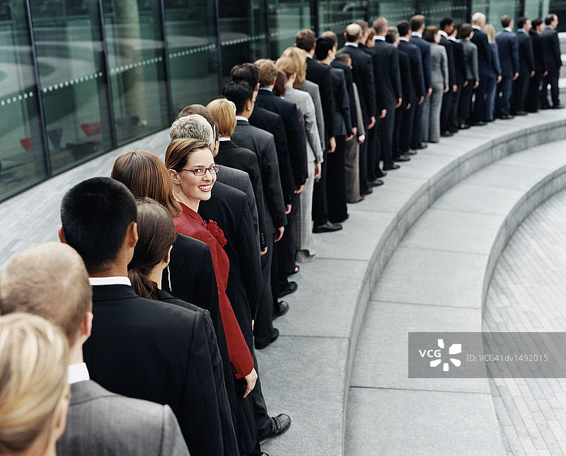 女商人站在一排等候在户外台阶上的商人中图片素材
