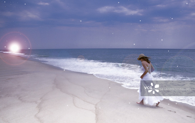 美国，纽约，长滩，年轻女子走在海滩上图片素材