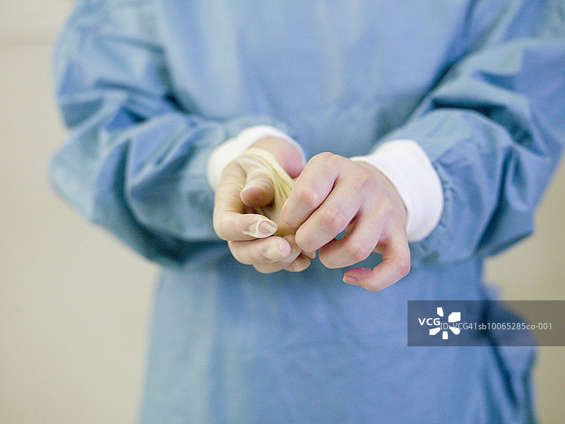 外科医生在医院调整医用手套，中段图片素材